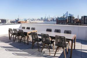 霍博肯Dharma Home Suites Hoboken的建筑物屋顶上的桌椅