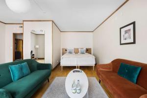 埃斯基尔斯蒂纳贝斯特韦斯特广场酒店的客厅配有两张绿色沙发和一张床