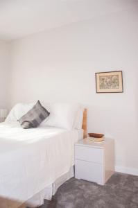 都柏林2 bed 2 bath Apartment with Canal View的一张带枕头和床头柜的白色床