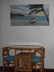 耐莉湾奥斯卡尔雨林住宿加早餐旅馆的一张桌子和两把椅子,墙上挂着一张照片