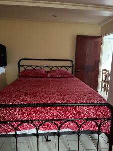 罗索TETE Comforts的卧室内的一张床位,配有红色棉被