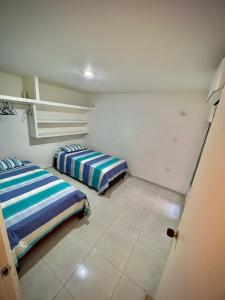 巴耶杜帕尔Acogedor apartamento amoblado con parqueadero的一间客房内配有两张床的房间
