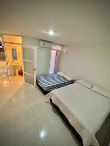 巴耶杜帕尔Acogedor apartamento amoblado con parqueadero的一间卧室设有两张床,一扇门通往浴室