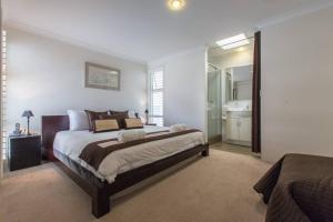 珀斯Beach View Apartment in Cottesloe的一间带大床的卧室和一间浴室