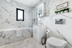 斯劳Modern 4 Bedroom House With Parking in Farnham Royal, Slough By Ferndale的白色浴室设有大理石墙壁和卫生间。