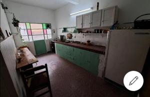 Treinta y TresCasa Agni的厨房配有绿色和白色的橱柜和冰箱。