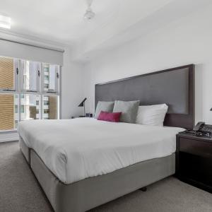 达尔文米切尔H公寓式酒店的一间卧室设有一张大床和一个窗户。