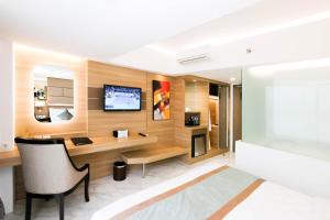 库塔Dream of Aventus Hotel Kuta的客厅配有书桌和电视。