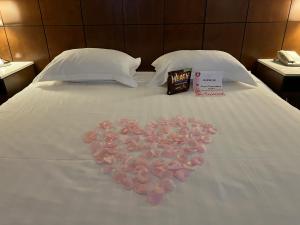 卡森LA Crystal Hotel -Los Angeles-Long Beach Area的床上玫瑰花瓣制成的心