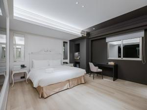台北芝山璞旅的卧室配有一张白色大床和一张书桌