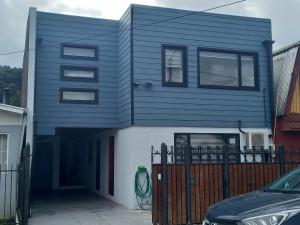 特木科Cabañas y Departamentos Las Palmas, Temuco Depto 3的蓝色的房子,前面有停车位