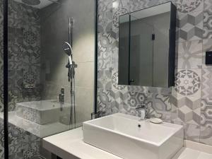 加央ALL IN HOTEL的一间带水槽、镜子和淋浴的浴室