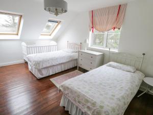 路易斯堡Springwood Cottage的一间卧室设有两张床、一张桌子和窗户。