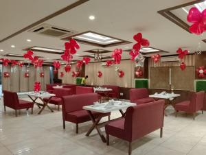 丹巴德Hotel Madhuvan by TravelkartOnline的餐厅设有桌子、红色椅子和气球
