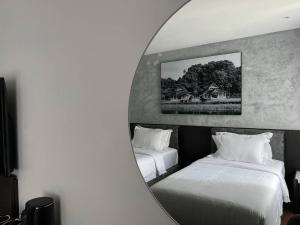 加央ALL IN HOTEL的镜子反射着一间带两张床的卧室和一座房子
