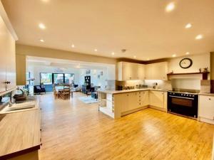 彭里斯Elegant & spacious farmhouse with wonderful views的一间大厨房和铺有木地板的客厅