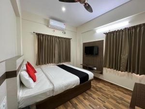 班加罗尔Hotel JP Grand的一间卧室配有一张床和一台平面电视