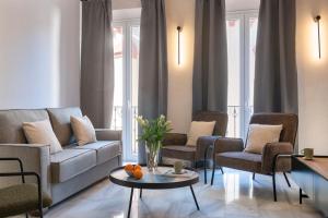 塞维利亚Magno Apartments San Gil - Shared Jacuzzi的客厅配有沙发、椅子和桌子