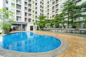 切特-希利尔RedLiving Apartemen Serpong Green View - Hapukh Room Tower B的大楼前的大型蓝色游泳池