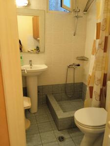 凯瑟拉Kouvaras Apartments的一间带水槽、卫生间和淋浴的浴室