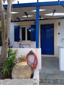 凯瑟拉Kouvaras Apartments的一座有蓝色门和红色软管的房子