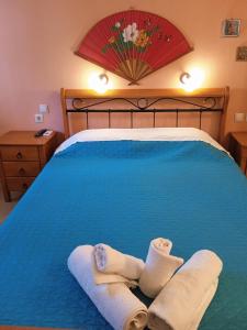 凯瑟拉Kouvaras Apartments的一间卧室配有蓝色的床和毛巾