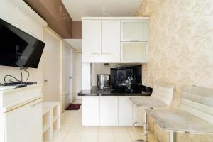 切特-希利尔RedLiving Apartemen Serpong Green View - Sheena Property Tower B的白色的厨房配有白色橱柜和电视。