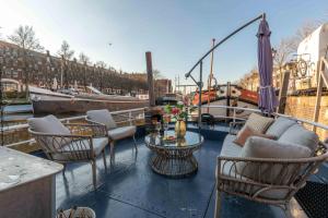 兹沃勒The luxury Boat的阳台配有桌椅和船只。