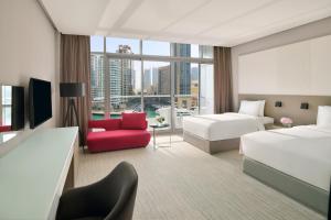 迪拜迪拜码头洲际酒店的酒店客房,设有两张床和一张红色椅子