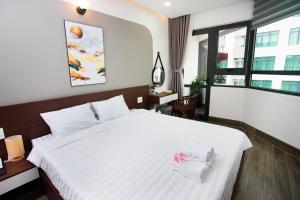 芽庄Tesoro Hotel的卧室配有白色的床和窗户。