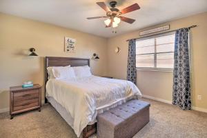 克洛维斯Charming Clovis Home with Covered Patio!的一间卧室配有一张带吊扇和窗户的床。