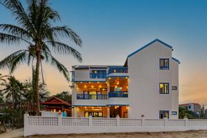 Tân Thành (1)LOCAL BEACH FRONT VILLAS的海滩上的白色房子,棕榈树