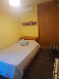 圣玛丽亚港Chalet Valdelagrana的一间小卧室,配有白色的床和黄色的墙壁