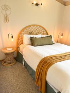 坎贝尔港PC度假屋的一间卧室配有一张大床和木制床头板