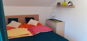 利马诺瓦Mieszkanko z tarasem的一间卧室配有带色彩缤纷枕头的床