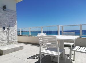 加利波利阿提科迪亚曼特公寓的阳台上配有白色的桌椅,享有海景