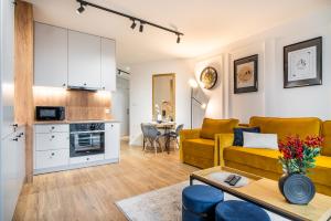 拉多姆ApartamentySnu, Struga Tower Gold z parkingiem的客厅配有黄色的沙发和桌子