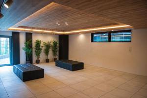 大阪QUEENS PARK的一间拥有两株植物、一张沙发和天花板的房间