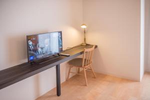 大阪QUEENS PARK的一张桌子,电视机和椅子放在房间里