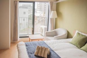 大阪QUEENS PARK的一间卧室配有一张带椅子的床和一扇窗户
