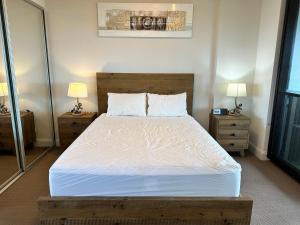 悉尼Best location apartment in Olympic park的一间卧室配有一张带2个床头柜的大床