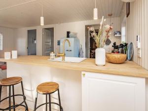 凯特明讷Holiday home Kerteminde XII的厨房配有2把吧台凳和水槽