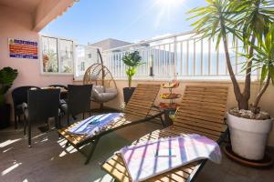 杜布罗夫尼克Apartment Rose Pool Comfort的一个带桌椅的阳台和一棵棕榈树