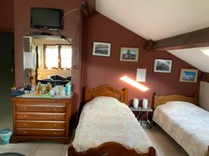 Trivières卡萨帝利昂住宿加早餐旅馆的一间卧室配有两张床和一个带镜子的梳妆台