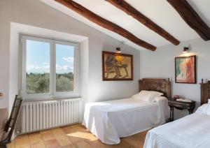 巴利-略夫雷加Finca Mas Gotas Costa Brava - BY EMERALD STAY的一间卧室设有两张床和窗户。
