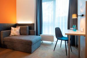 斯图加特ACHAT Hotel Stuttgart Airport Messe的客厅配有沙发、椅子和桌子