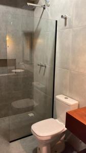 伊卡普伊Lyttos Bungalows的一间带卫生间和玻璃淋浴间的浴室