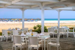 哈马马特The Mirage Resort & SPA的海滩上带桌椅的餐厅