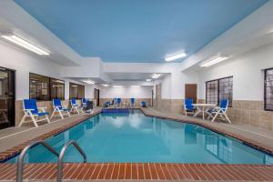 PrattBaymont by Wyndham Pratt的一个带蓝色椅子和桌子的游泳池