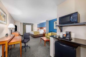 PrattBaymont by Wyndham Pratt的酒店客房带起居室,带一张床。